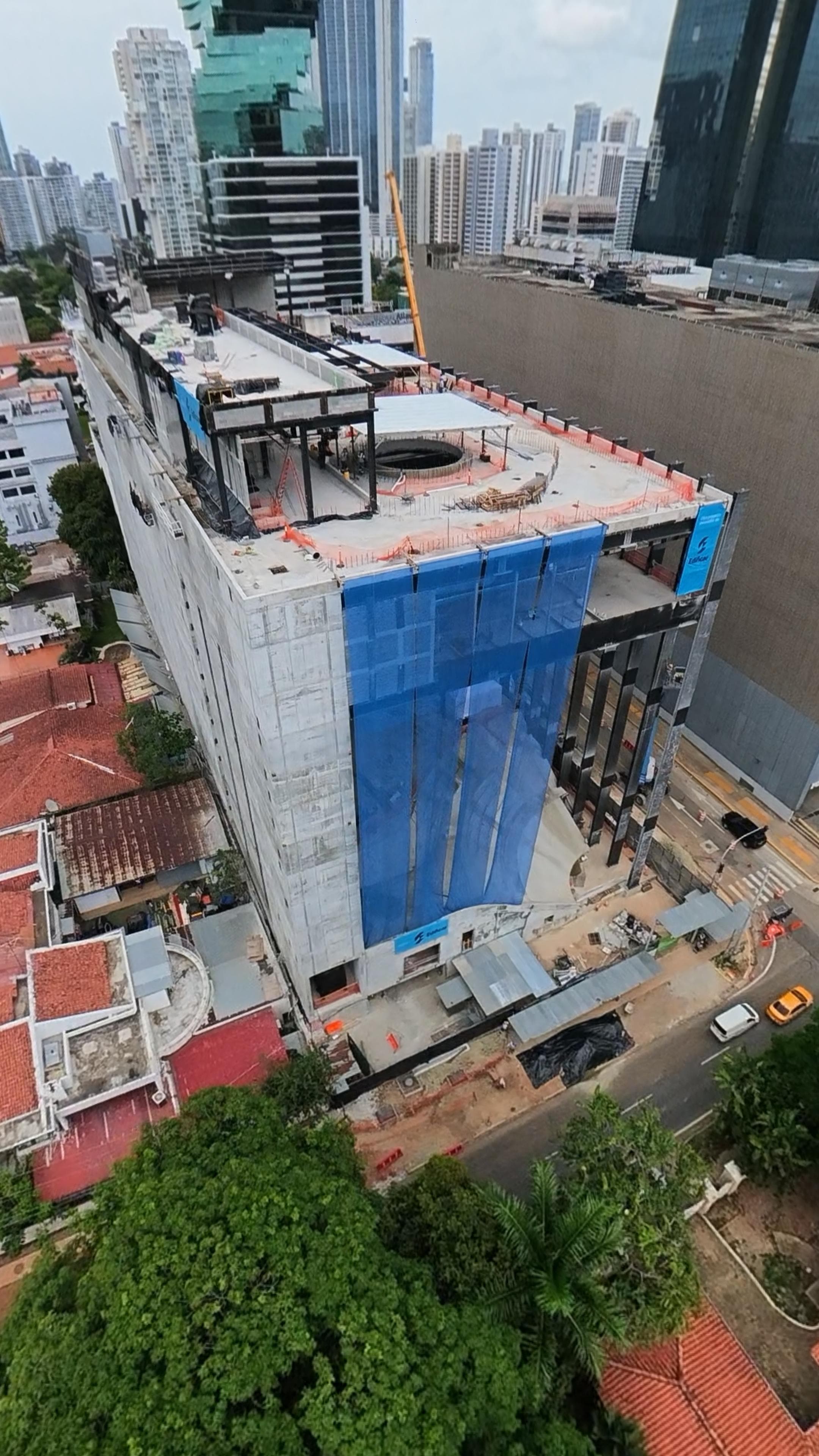 Vista aérea de la fachada metálica del Edificio CAF con el skyline de la ciudad al fondo.