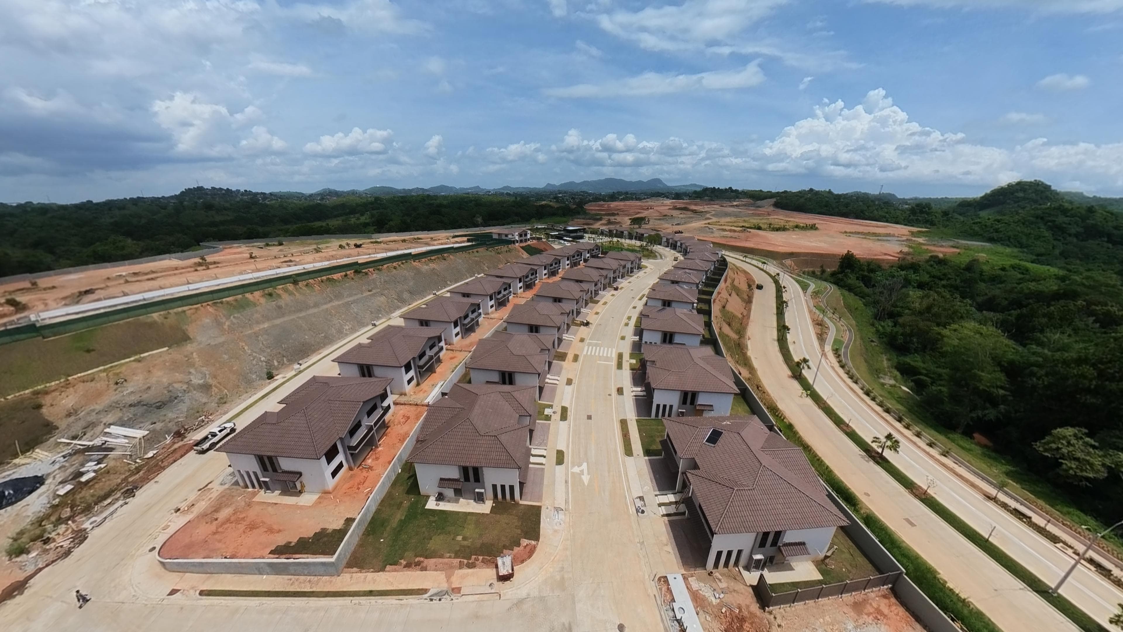 Hileras de residencias terminadas de Canyons sobre el talud, con las montañas de Panamá Norte al fondo.