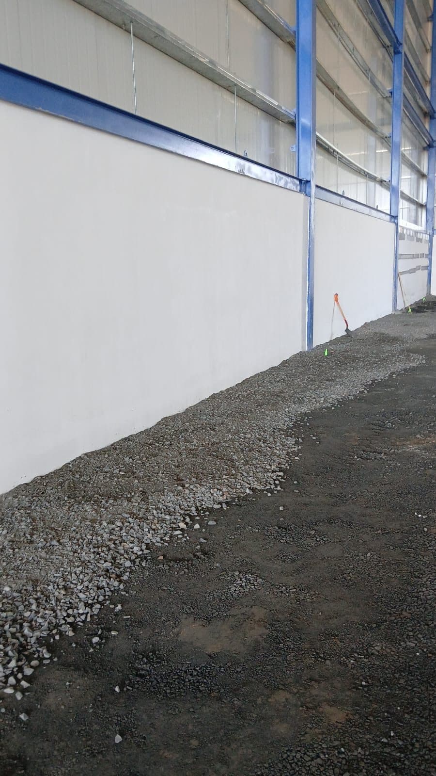 Muro terminado con panelería y estructura metálica de la planta ampliada, vista vertical.